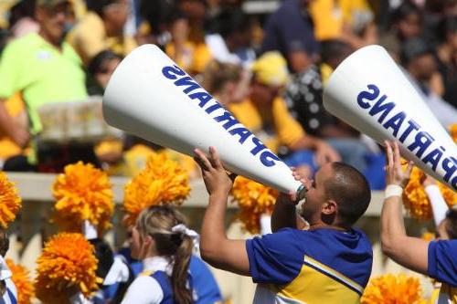 male cheerleader using a "spartan" megaphone at football game