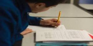 student taking notes with pencil and notebook