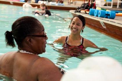 Two women stand in a swimming pool at the Timpany Center.